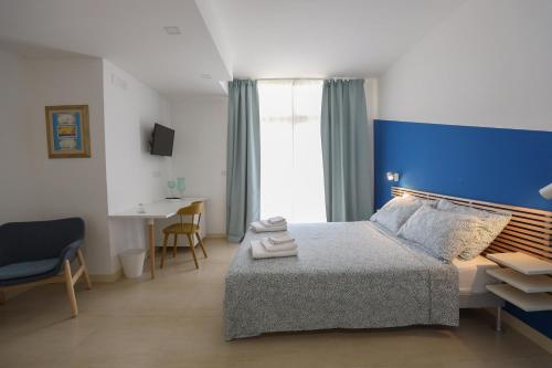 Habitación de hotel con cama y pared azul en Affittacamere Aria Di Mare en Paestum
