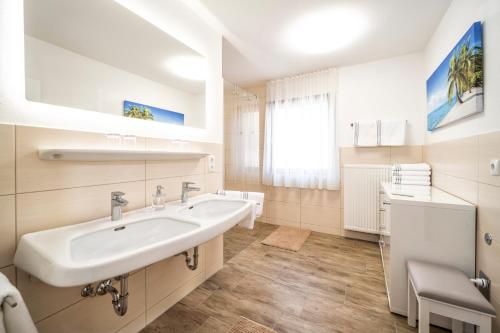 La salle de bains blanche est pourvue d'un lavabo et d'un miroir. dans l'établissement Haus Kindler, à Radstadt