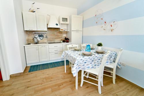 cocina con mesa y sillas en una habitación en Isola Rossa Beach House, en Isola Rossa