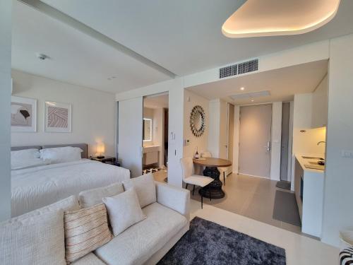 a bedroom with a white bed and a couch at Veranda Residence Hua Hin 1BR Beachfront in Hua Hin
