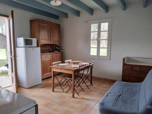 une cuisine avec une table et un réfrigérateur blanc dans l'établissement LE PETIT FROUAS SUD, à Vielle-Saint-Girons