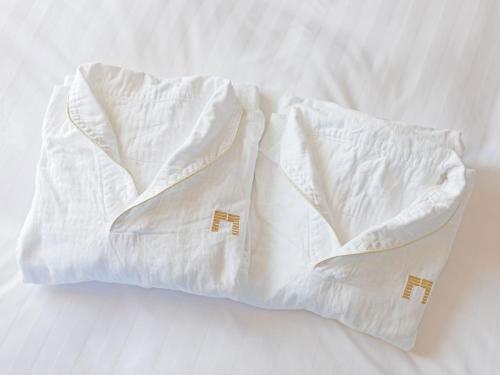 
a white towel wrapped around a white pillow on top of a bed at The Gate Hotel Asakusa Kaminarimon by Hulic in Tokyo
