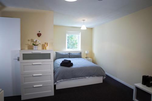 a bedroom with a bed with a dresser and a window at Central studio in quiet area in Newbury