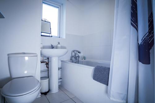 a white bathroom with a toilet and a sink at Central studio in quiet area in Newbury