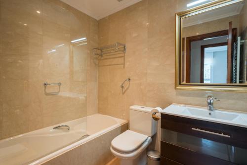 a bathroom with a toilet and a tub and a sink at Zubia apartment by People Rentals in Bilbao