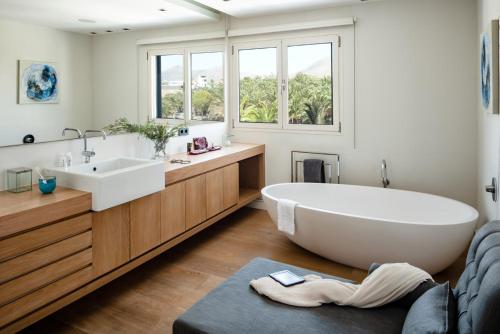 Un baño con una bañera grande y un lavabo. en SERENITY by Buenavilla, en Puerto Calero
