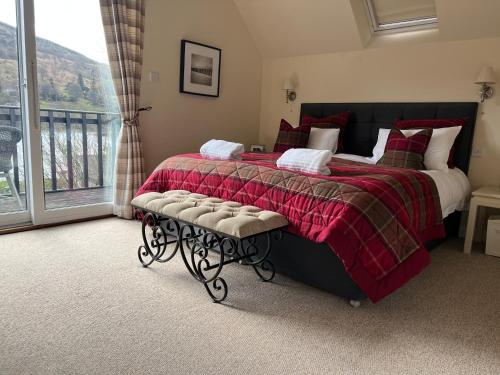 a bedroom with a bed with a red blanket and a window at Chefs cottage in Kenmore