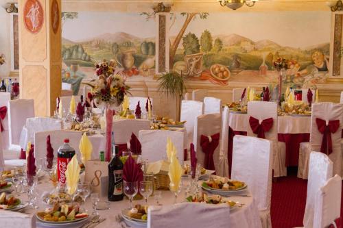 a dining room with white tables and white chairs at Casa Traiana in Alba Iulia