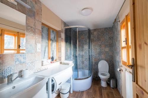 ein Badezimmer mit einer Badewanne, einem Waschbecken und einem WC in der Unterkunft Drevenica RAKŠA 11 in Rakša