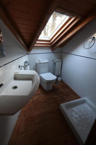 a bathroom with a toilet and a sink and a window at Casa Grande da Capellania in Padrón