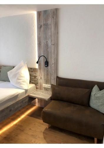 a bedroom with a bed and a couch and a lamp at Ferienhof Oberer Gollmitzer in Heiligenblut