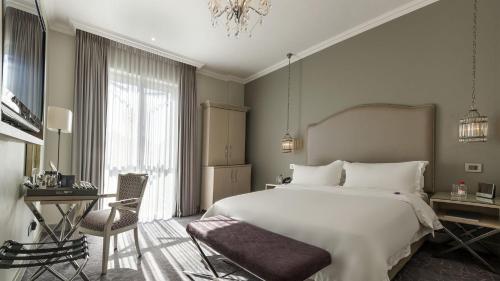 a bedroom with a bed and a desk and a chair at Queen Victoria Hotel by NEWMARK in Cape Town