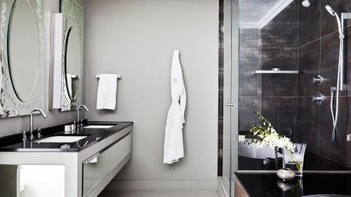 a bathroom with a sink and a shower at Queen Victoria Hotel by NEWMARK in Cape Town
