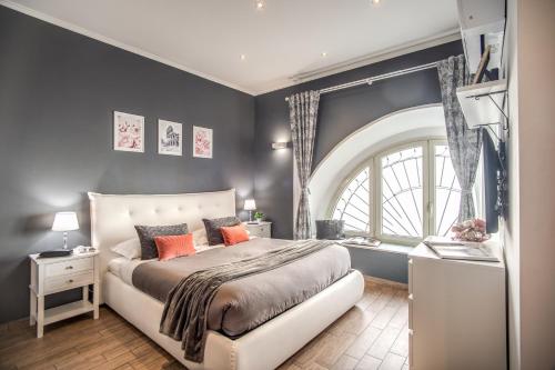 sypialnia z dużym łóżkiem i dużym oknem w obiekcie Colosseum Royal Apartment w Rzymie