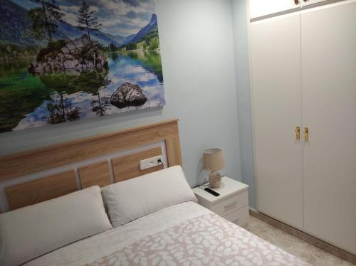 een slaapkamer met een bed en een schilderij aan de muur bij Maria Guerrero Cala Pinchosos in Cabo de Palos