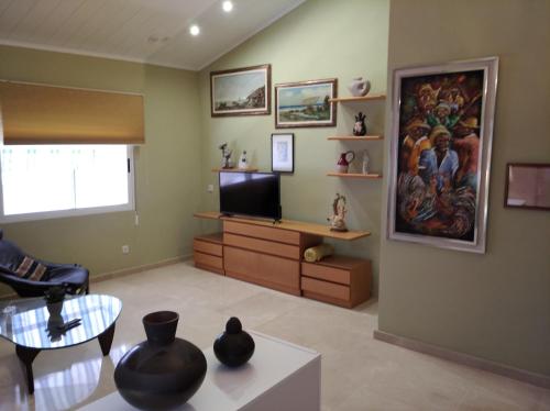 a living room with a flat screen tv and a table at Maria Guerrero Cala el Pato in Cabo de Palos