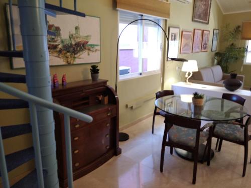 un soggiorno con tavolo in vetro e scrivania di Maria Guerrero Cala el Pato a Cabo de Palos