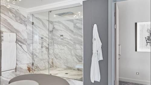 a bathroom with a shower with a glass door at Queen Victoria Hotel by NEWMARK in Cape Town