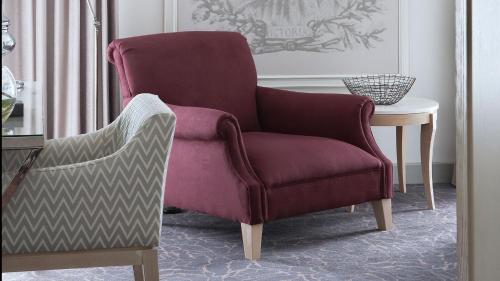 a burgundy chair sitting next to a table at Queen Victoria Hotel by NEWMARK in Cape Town