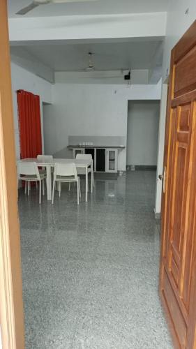 an empty room with white chairs and a table at Retaj Residency in Ernakulam