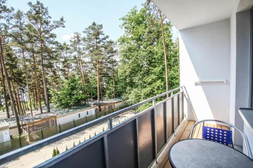 a balcony with a table and chairs and trees at Hotel U Pláže in Vranov nad Dyjí
