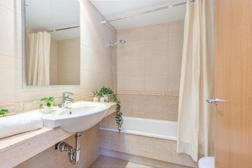 Un baño con lavabo y ducha con espejo. en CONFORT APARTMENT, en Roses