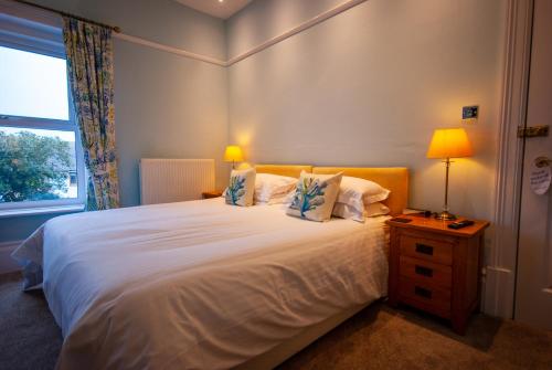 a bedroom with a large white bed with a window at Westbury Lodge in Shanklin