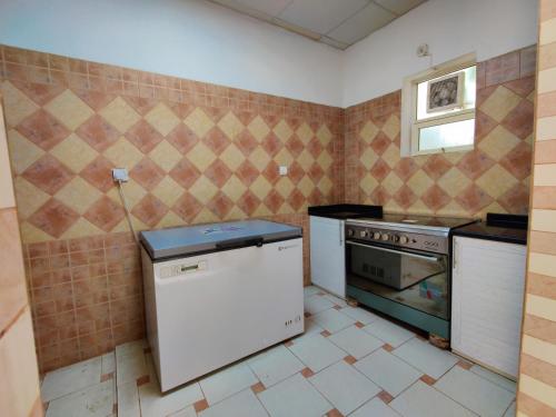 a kitchen with a refrigerator and a stove in it at Sara Farm in Abu Dhabi