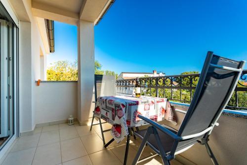 a table and a chair on a balcony at Apartments Jelena Vantačići in Vantačići