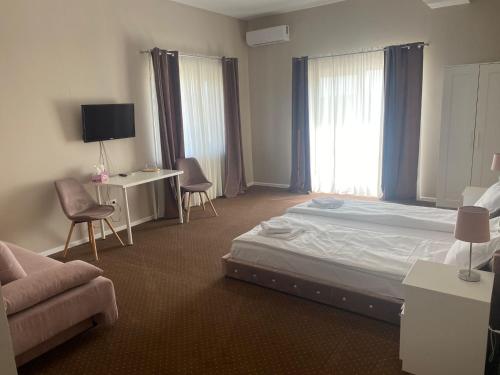 a bedroom with a bed and a desk and a couch at B&B Andero Deva in Deva