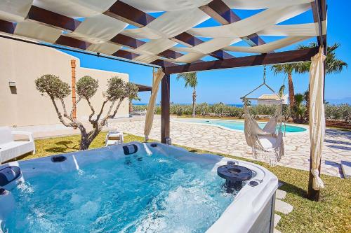 a hot tub in a backyard with a pergola at Villa delle Stelle in Scopello