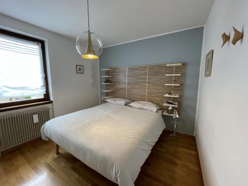um quarto com uma cama branca e uma janela em 034 Splendido Trilocale Pinzolo em Pinzolo