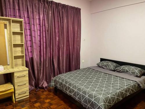 - une chambre avec un lit et un rideau pourpre dans l'établissement JML Family Homestay ~ Entire Residential Home, à Kota Kinabalu