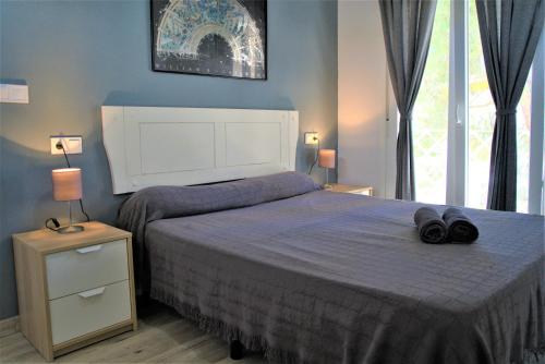 una camera da letto con un letto e due asciugamani di Chalet blanco con piscina privada a Isla Cristina