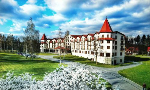 a large white building with a red roof at Hotel Nowy Zdrój - Centrum Zdrowia i Wypoczynku in Polanica-Zdrój