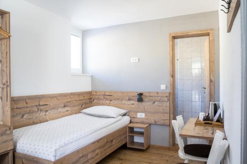 a bedroom with a bed and a desk with a computer at Hiša Poljana Rooms in Prevalje