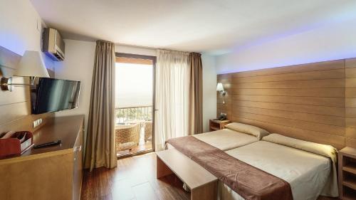 a hotel room with a bed and a window at Hotel Sierra de Cazorla & SPA 3* in Cazorla