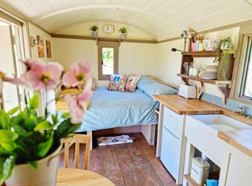 Habitación con cama y cocina con fregadero en Pen Bryn Shepherd Hut, en Hay-on-Wye