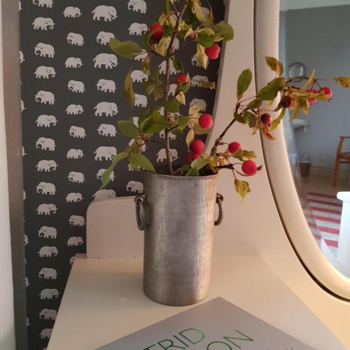 a plant in a metal pot on a table at Villa Eira vandrarhem in Hjo