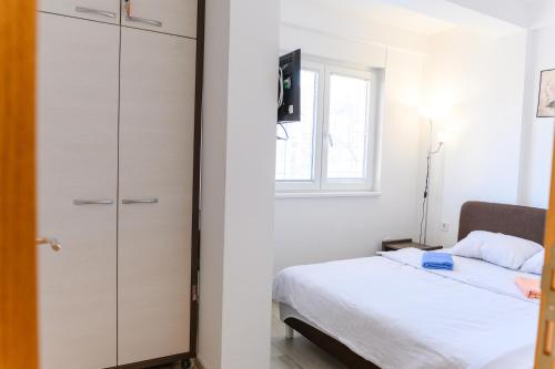 a bedroom with a closet and a bed and a window at Apartman Saga Premium Garaza Parking Vauceri Ne in Soko Banja