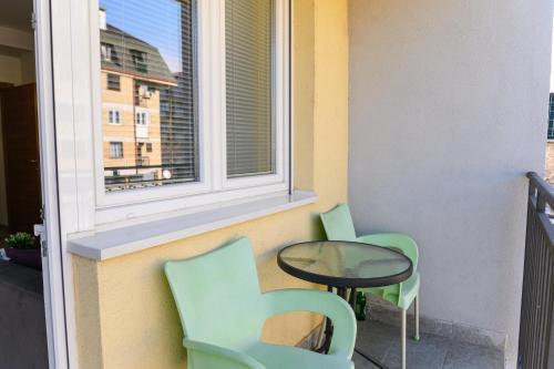 a balcony with two chairs and a table and a window at Apartman Saga Premium Garaza Parking Vauceri Ne in Soko Banja
