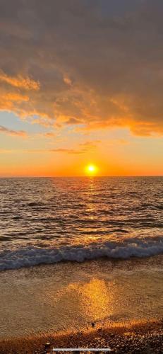a sunset on the beach with the ocean at Valenti rooms & relax in Villaggio Mosè