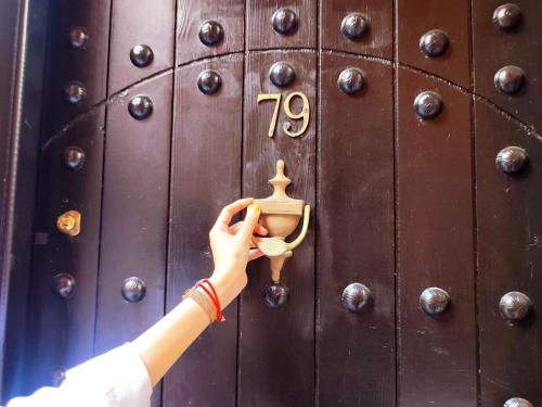 a person is opening a lock on a wooden door at Riad Nour Resorts-Riad Nour Travel in Marrakech