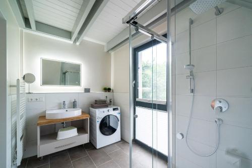 ein Badezimmer mit einem Waschbecken und einer Waschmaschine in der Unterkunft Domizil am Ostseewald - Haus Zaunwinde in Zingst