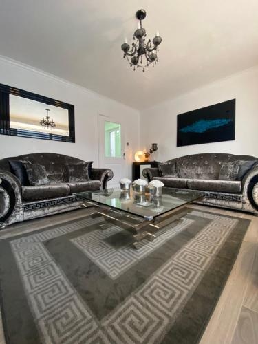 a living room with two leather couches and a table at NEW…THE HOTTUB HOUSE BLACKPOOL PLEASURE BEACH in Blackpool