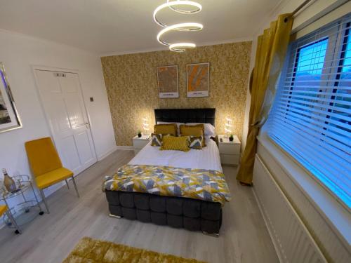 a bedroom with a bed and a yellow chair at NEW…THE HOTTUB HOUSE BLACKPOOL PLEASURE BEACH in Blackpool