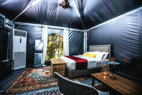 ein Schlafzimmer mit einem Bett und einem Tisch in einem Zelt in der Unterkunft Le Quadri Hotel Kuala Lumpur in Kuala Lumpur