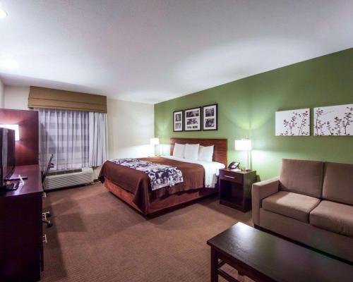 a hotel room with a bed and a couch at Sleep Inn & Suites Edmond near University in Edmond