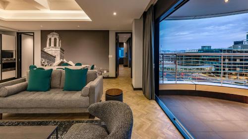 a living room with a couch and a large window at The Onyx Apartment Hotel by NEWMARK in Cape Town
