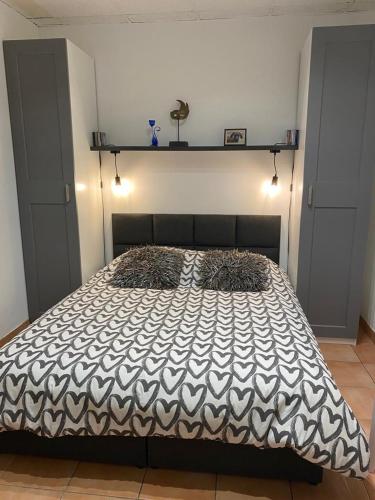 une chambre avec un lit avec une couette noire et blanche dans l'établissement L'Xpérience au bord de mer, à Port-Vendres